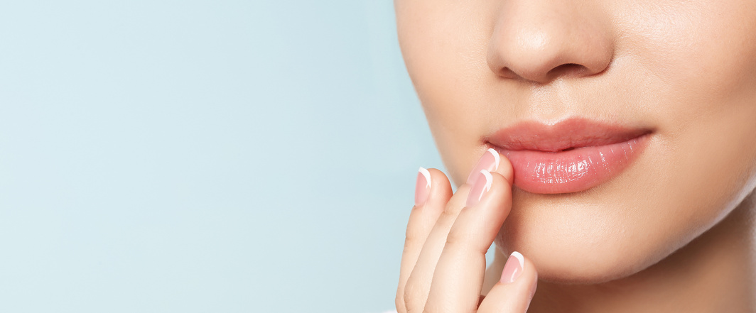Eine Frau mit schönen Lippen berührt sanft ihre Lippen mit dem Finger.